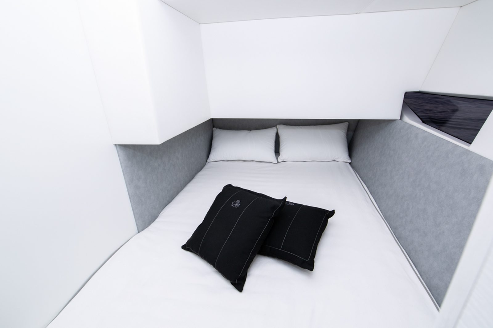 La cabina ospiti sottocoperta, con il letto rifatto e i cuscini del cantiere.
